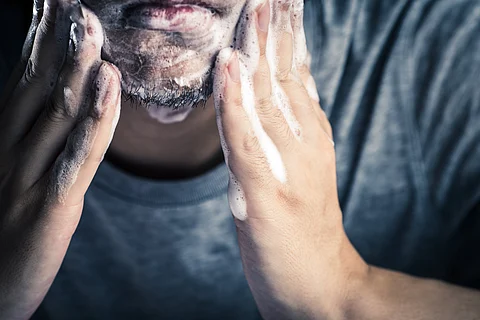 man using facial cleanser