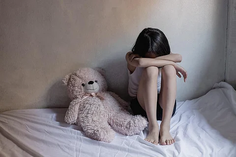 Niña triste sentada en la habitación. Concepto de trata de personas.