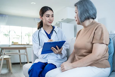 El médico de psicología del cuidador asiático examina y escucha a la paciente mujer. La enfermera joven y hermosa da consejos y consulta para ayudar a las mujeres mayores a resolver problemas en el hogar de ancianos. Atención psicológica de la salud.