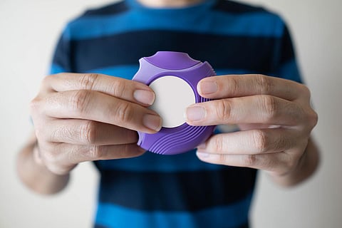 Hombre joven que usa inhalador de polvo seco de medicina para el tratamiento del asma o enfermedades de EPOC. El producto farmacéutico se utiliza para tratar la inflamación pulmonar y prevenir el ataque de asma. Cerrar.