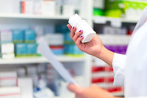 Clienta en la farmacia tomando una caja de medicamentos