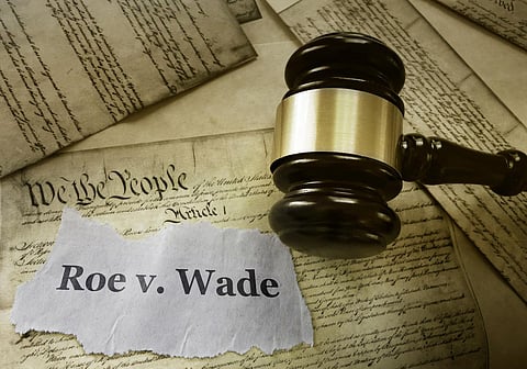 Roe v Wade news headline with gavel on a copy of the United States Constitution