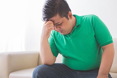 Retrato de un hombre con sobrepeso deprimido pensando en su problema de peso