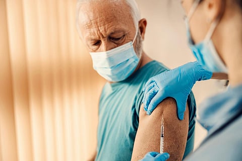 Un anciano recibiendo la vacuna covid 19 en el hospital. Vacunación, inoculación y atención médica.