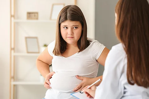 Niña triste con sobrepeso que visita al nutricionista en la clínica