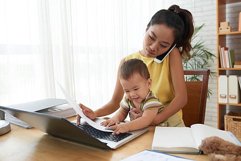 Young woman working with baby on her knees