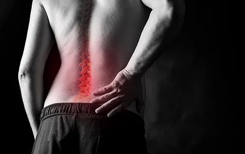 severe back pain. the man holds on to his back