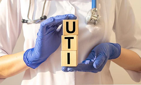 Concepto de uti de palabras, inscripción de infección del tracto urinario en cubos en manos de médicos.