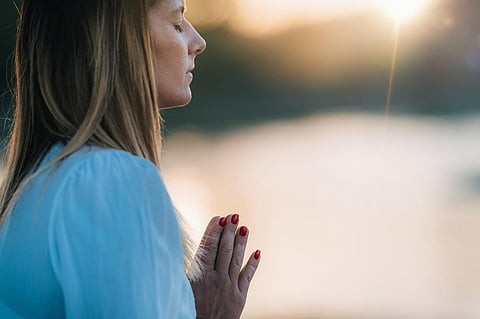 Woman Meditating by the Lake. Prayer Position.