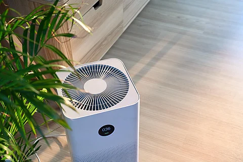 Purificador de aire sobre suelo de madera en un hogar confortable. Aire fresco y vida sana.