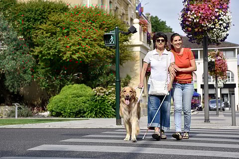 Mujer ciega mayor cruzando la calle con ayuda
