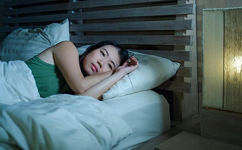 estilo de vida noche retrato de joven hermosa deprimida y triste mujer asiática china que tiene insomnio acostada en la cama sin dormir sufriendo ansiedad estrés y depresión problema de pensamiento preocupado