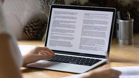 Close up view of modern technology digital gadget opened computer with electronic documents on screen. Young woman preparing report or reading scientific article, studying at home, education concept.