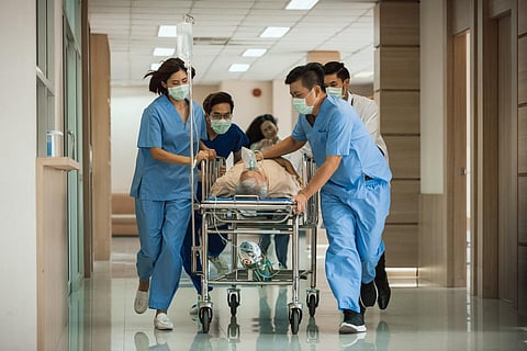 Emergency Department: Group of Doctors, Nurses, Paramedics Push Gurney, Stretcher with Seriously trauma Patient towards the Operating Room.