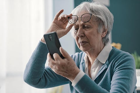 Mujer mayor con problemas de visión, no puede leer los mensajes en su smartphone