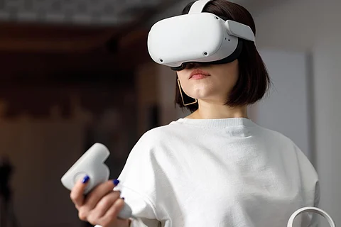 equipo de cuatro ingenieros creativos que trabajan con realidad virtual, mujer joven que prueba gafas de realidad virtual o gafas sentadas en la sala de oficina