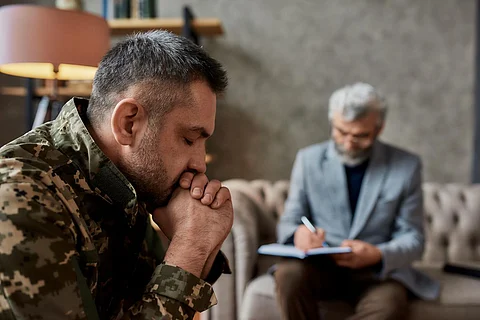Un militar de mediana edad cerró los ojos durante una sesión de terapia con un psicólogo. Soldado que sufre de depresión, trauma psicológico. Concepto de trastorno de estrés postraumático. Disparo horizontal. Perfil. Enfoque en las fuerzas armadas