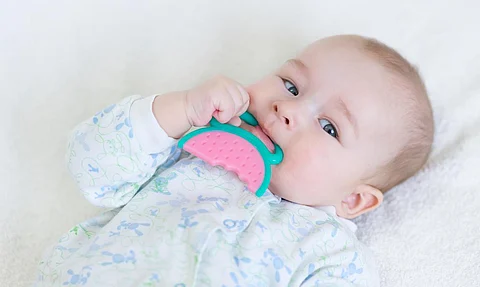 painful teething in infants, baby close-up with a toy