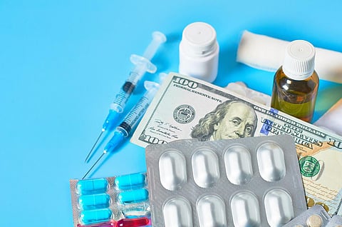 Diferentes medicamentos y dinero sobre fondo azul. Concepto médico. Sueldo del médico. Corrupción en la sanidad. Compra de medicamentos. Seguro de enfermedad. Costo de fabricación de la vacuna contra el virus