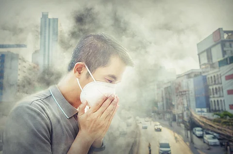 Asian man wearing the N95 Respiratory Protection Mask against air pollution at road and traffic in Bangkok