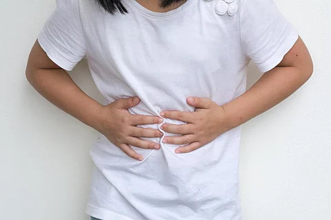 Woman Child's hands on her stomach with red spot as suffering on stomachache. Girl school kid suffer from Chronic Diarrhea,Digestive Disorders, stomach pain,Crohnâs Disease, irritable bowel syndrome