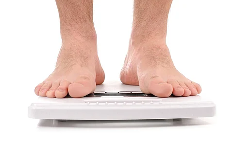Diet concept. Man standing on weight scale