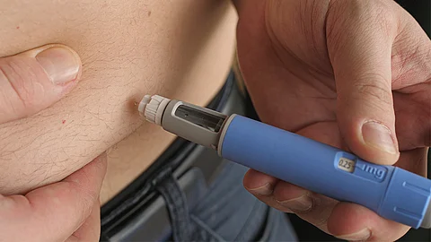 Man giving himself semaglutide injection, Ozempic, Wegovy