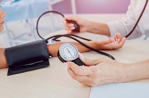 Médico midiendo la presión arterial de una niña.