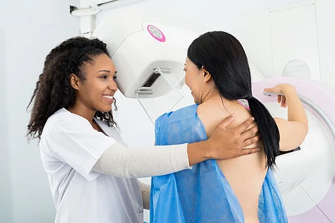 Happy Doctor Asistiendo a la Mujer que Se Somete a la Prueba de Rayos X de la Mamografía