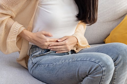Mujer se agarra el estómago con dolor Sufre dolor de estómago o menstruación