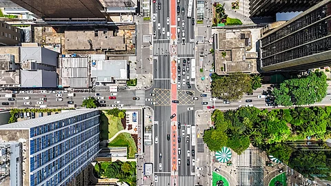 Visão aérea da intersecção da Avenida Paulista, São Paulo, Brasil, destacando o tráfego urbano, arranha-céus icônicos e a vibrante atmosfera da cidade