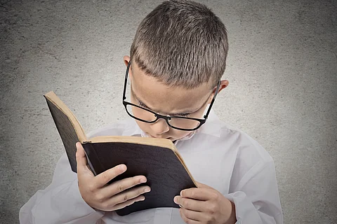 Niño, adolescente que tiene dificultad para leer textos, problemas de visión.