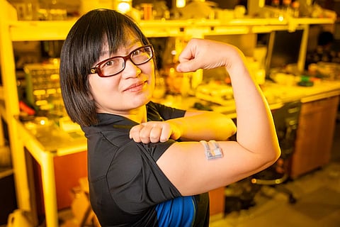 Xiaoyue Ni flexiona el brazo mientras usa un prototipo del nuevo sensor de rigidez tisular. El dispositivo podría sustentar una amplia gama de aplicaciones médicas, como el monitoreo de la cicatrización de heridas, afecciones crónicas como el cáncer de piel, el manejo de fluidos durante los esfuerzos de reanimación y la rehabilitación muscular.