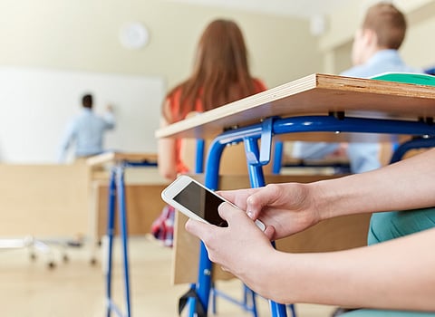 Estudiante al teléfono en el aula