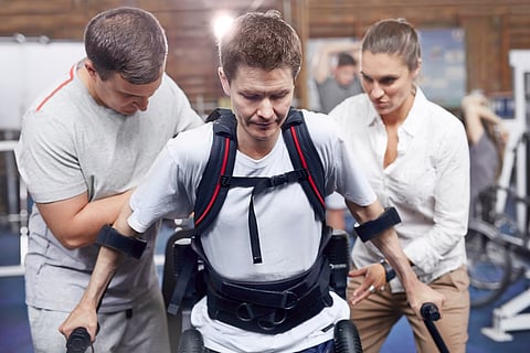 Fisioterapeutas guiando al hombre caminando