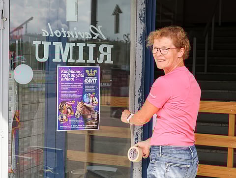 Anu Suokas maalaa ovenpieliä katsomon luona.
