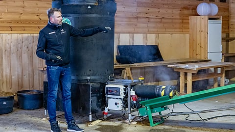 Vesa Kukkamo esittelee Manpas-laitteistoa Stall Blombacken tiloissa. Laitteisto vaatii jonkin verran tilaa ja traktoriin etukuormaajan. Kuvassa on ensimmäisessä kokeessa käytetty pienempi laite, nykyään tilalla on isompi versio.
