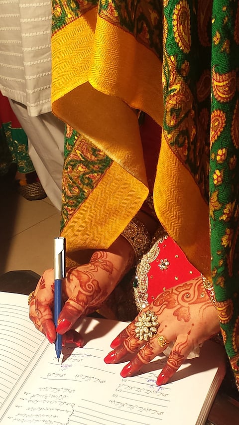 A bride signing a marriage certificate in Urdu. Many British Southasians choose to marry partners from Southasia.
Photo : Wikimedia Commons / S.M. Samee