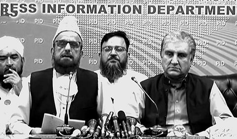 Pakistan's Foreign Minister Shah Mahmood Qureshi (right) and religious leader Mufti Muneebur Rehman (left) address a press conference in late October 2021, to announce that the government had reached an agreement with the banned group Tehreek-i-Labbaik Pakistan (TLP) following violent protests by the members of the group. The ban was revoked the following month. Photo: Screengrab / DawnNews TV