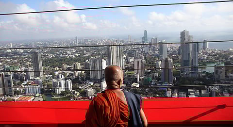 A Buddhist monk looks out at Colombo from the Lotus Tower, one of many infrastructure projects built by the Rajapaksas with Chinese loans. China’s Buddhist-to-Buddhist diplomacy seems to have been born after the Rajapaksas were ousted in 2015. Photo courtesy: NurPhoto / IMAGO