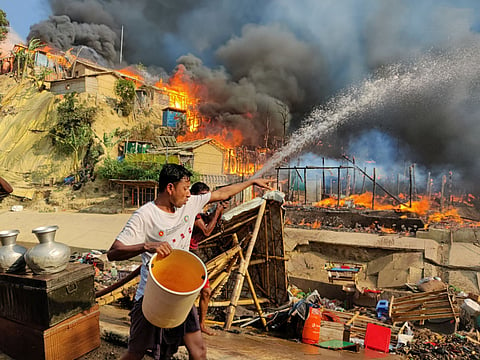 Young Rohingya refugees try to fight a massive fire that broke out in a refugee camp at Cox's Bazar on 5 March 2023. The situation in the Rohingya refugee camps was already dire, and a recent reduction in food rations is exacerbating their suffering. Photo: Sahat Zia Hero