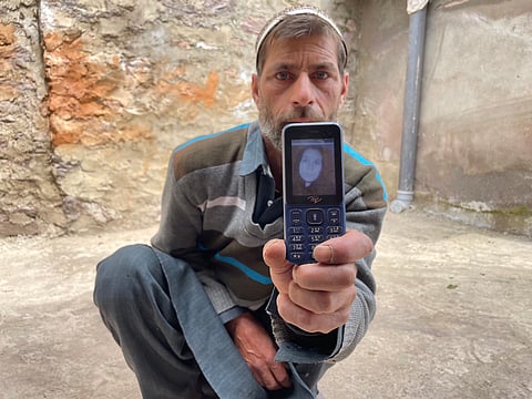 Bashir Ahmad Dar shows a picture of his slain wife. Farooqa Begum was killed by shelling across the Line of Control in Balkote, in India-administered Kashmir. Photo courtesy: Auqib Javeed