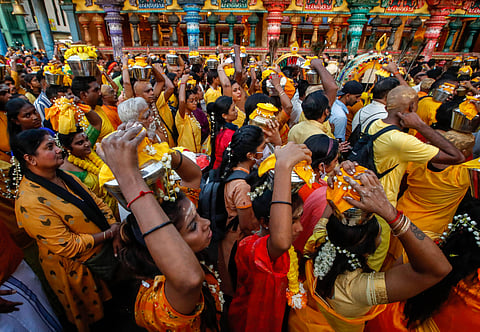 Hindu devotees carrying pots of milk on their heads as offering as they make their way toward Batu Caves temple during the Thaipusam festival. (This featured image was added online in 2024, and did not appear in the original print publication.)