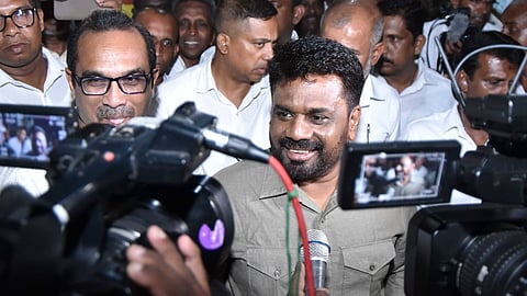 Anura Kumara Dissanayake wearing a grey shirt smiles at cameras outside his party office after winning Sri Lanka’s presidential election