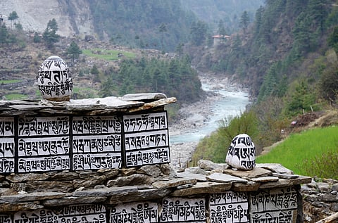 Buddhist mani stones with sacred mantras near Dudh Kosi river in Eastern Nepal. (This featured image was added online in 2024, and did not appear in the original print publication.)