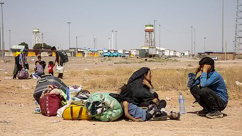 Afghan families rest on the ground after being deported from Iran at the Islam Qala crossing in Afghanistan.