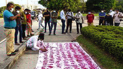 An art performance of laying down handprints in red paint on a white sheet to remember Black January which remembers journalist killings in Sri Lanka.
