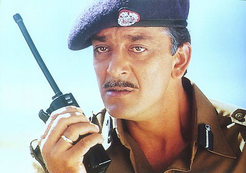 A still from the Hindi film Mission Kashmir featuring actor Sanjay Dutt wearing a military uniform and speaking into a walkie talkie.