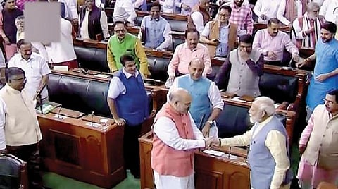 காஷ்மீருக்கு சிறப்பு அந்தஸ்து அளிக்கும் 370-வது சட்டப்பிரிவை நீக்கும் மசோதா நேற்று மக்களவையில் நிறைவேற்றப்பட்டது. இதையடுத்து மத்திய உள்துறை அமைச்சர் அமித் ஷாவுக்கு வாழ்த்து தெரிவிக்கிறார் பிரதமர் மோடி. படம்: பிடிஐ