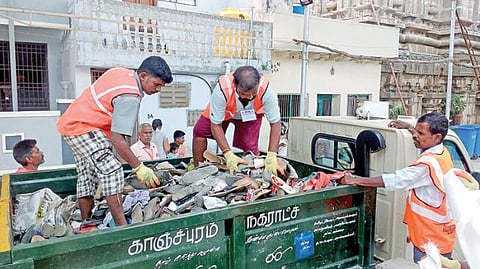 கிழக்கு ராஜகோபுரம் அருகே பக்தர்கள் விட்டுச் சென்ற காலணிகளை அப்புறப் படுத்தும் துப்புரவு தொழிலாளர்கள்.